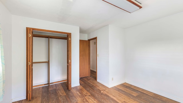 unfurnished bedroom with dark hardwood / wood-style floors and a closet