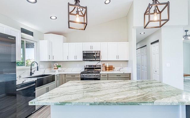 kitchen with white cabinetry, sink, pendant lighting, lofted ceiling, and appliances with stainless steel finishes