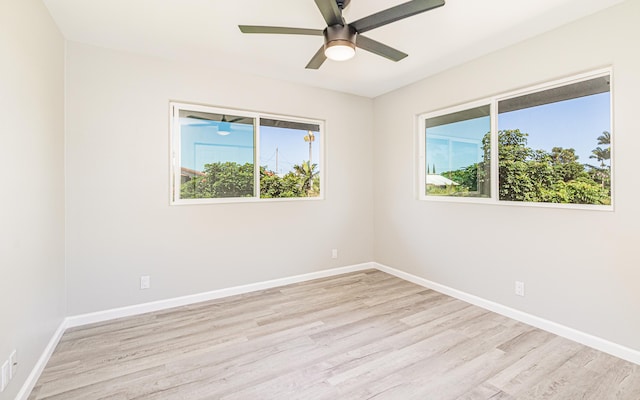 empty room with ceiling fan, a healthy amount of sunlight, and light wood-type flooring