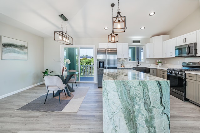 kitchen with white cabinets, hanging light fixtures, a center island, and stainless steel appliances