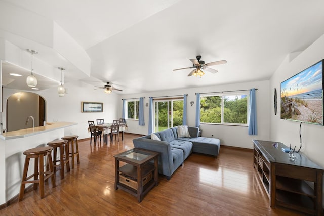 living room featuring dark hardwood / wood-style flooring, vaulted ceiling, and ceiling fan