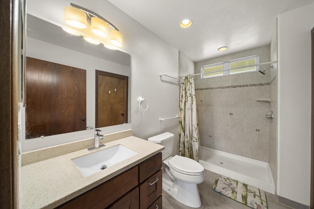 bathroom featuring a shower with curtain, vanity, toilet, and tile patterned floors