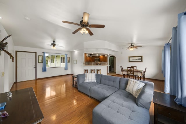 living room featuring wood-type flooring and ceiling fan