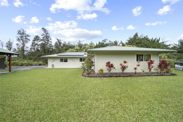 exterior space featuring solar panels and a front lawn