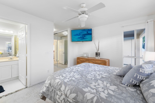 bedroom featuring a closet, ensuite bathroom, ceiling fan, and sink