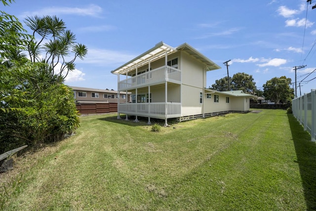 back of property featuring a balcony and a yard