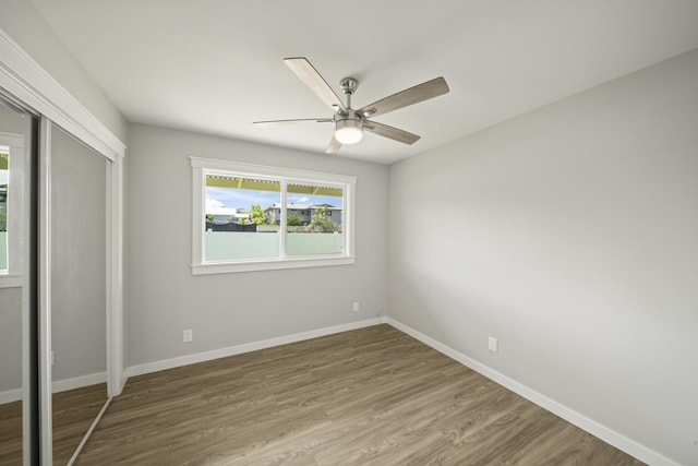 unfurnished bedroom with wood-type flooring, a closet, and ceiling fan