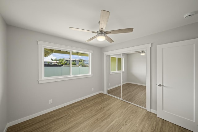 unfurnished bedroom with a closet, light hardwood / wood-style flooring, and ceiling fan