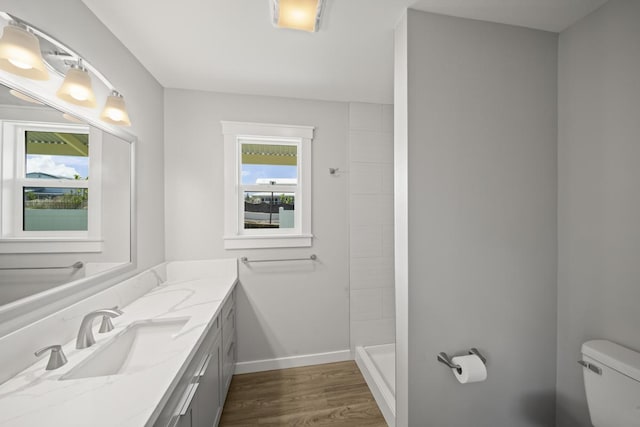 bathroom with a shower, toilet, vanity, and hardwood / wood-style flooring