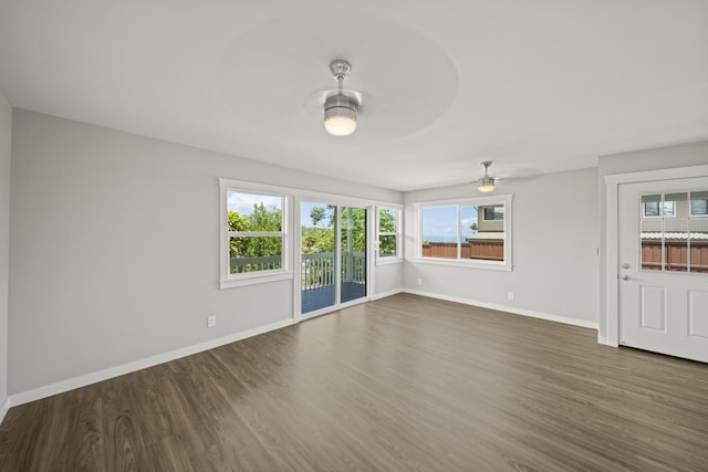 unfurnished living room with ceiling fan and dark wood-type flooring