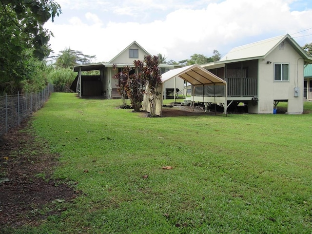 view of yard featuring a carport and a sunroom