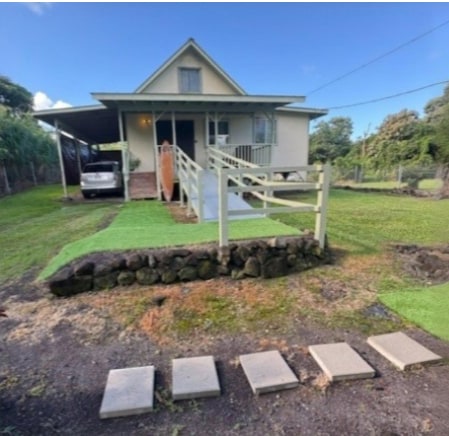 view of front facade featuring a front yard and a carport