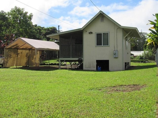 back of property with a sunroom and a lawn