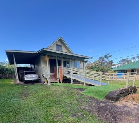 view of front of house with a carport and a front yard