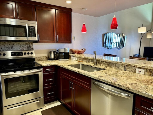 kitchen with pendant lighting, sink, light tile patterned floors, light stone counters, and stainless steel appliances