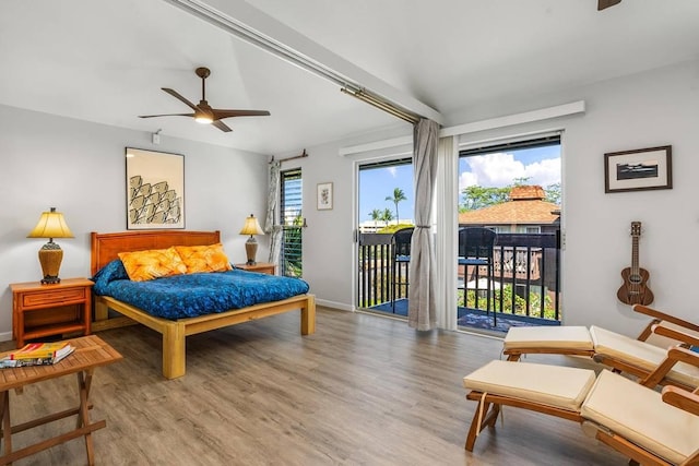 bedroom with hardwood / wood-style flooring, ceiling fan, access to exterior, and multiple windows