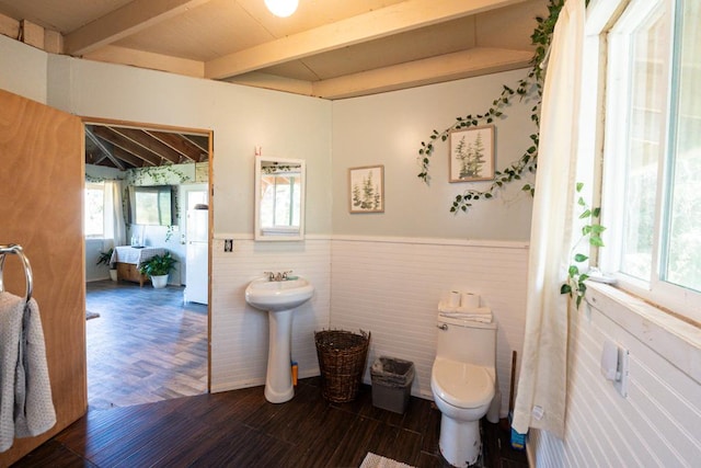 bathroom with hardwood / wood-style floors, beamed ceiling, and toilet