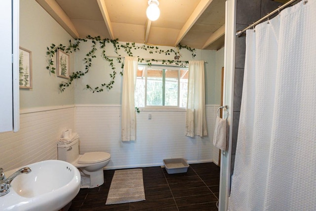 bathroom featuring tile patterned floors, toilet, walk in shower, and sink