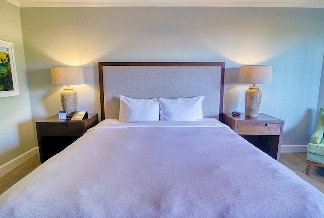 bedroom with crown molding and wood-type flooring