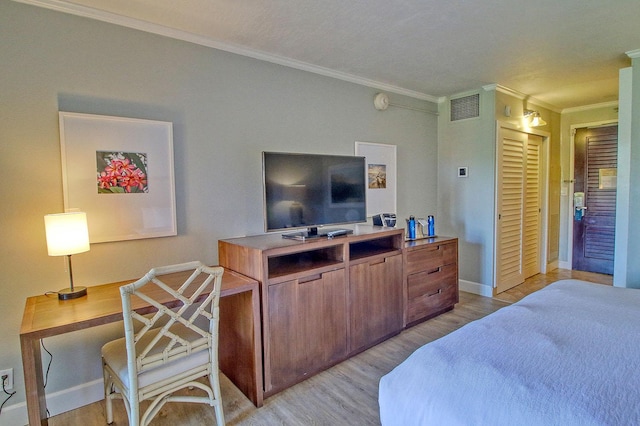 bedroom featuring a closet, light hardwood / wood-style floors, and ornamental molding