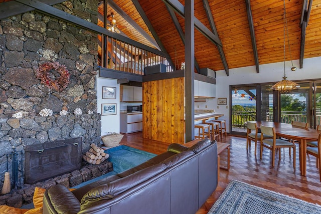 unfurnished living room featuring a fireplace, beam ceiling, high vaulted ceiling, and wooden ceiling