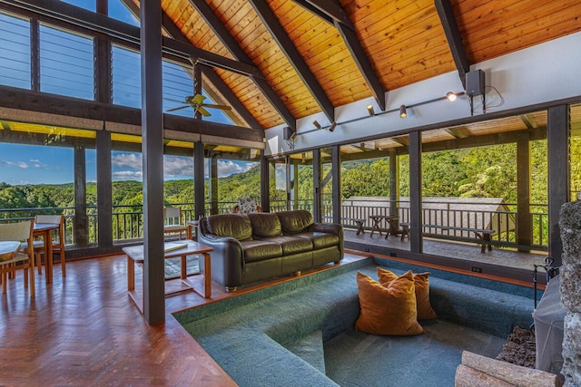 sunroom / solarium featuring vaulted ceiling with beams, ceiling fan, and wooden ceiling