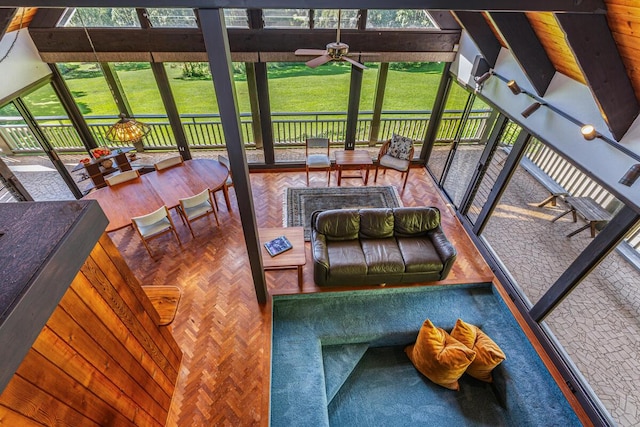 sunroom with lofted ceiling with beams, a wealth of natural light, and ceiling fan