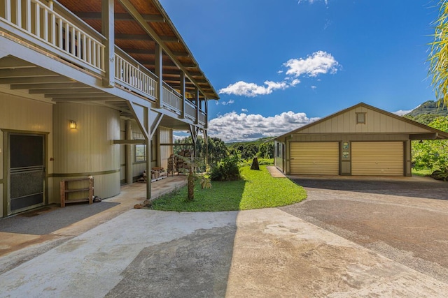 view of yard featuring an outbuilding, a balcony, and a garage