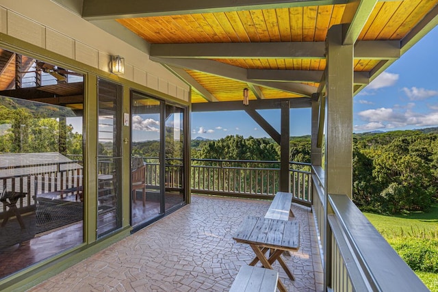 sunroom / solarium featuring beamed ceiling and wooden ceiling