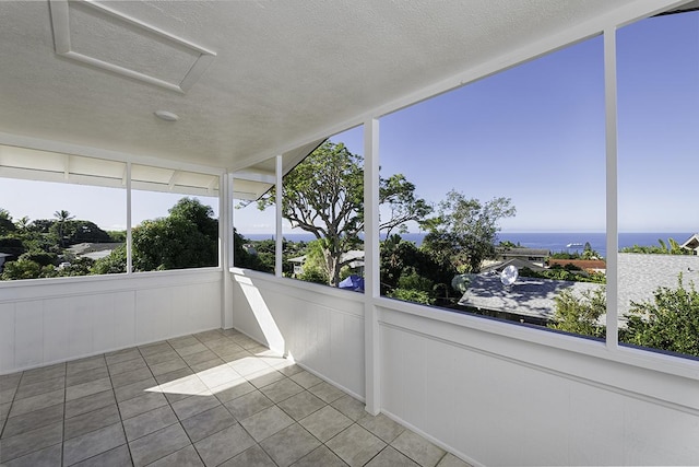 unfurnished sunroom featuring a water view