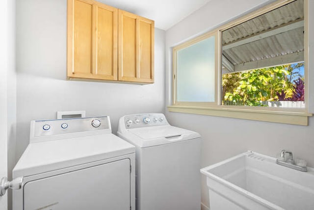 washroom with cabinets, sink, and washer and dryer