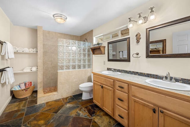 bathroom featuring vanity, toilet, walk in shower, and a healthy amount of sunlight