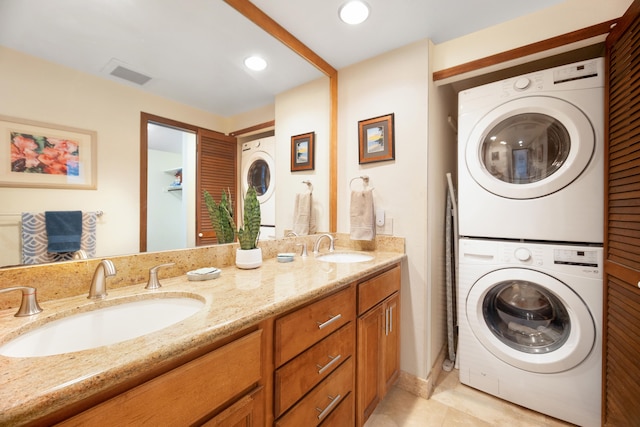 bathroom with tile patterned flooring, stacked washer / drying machine, and vanity