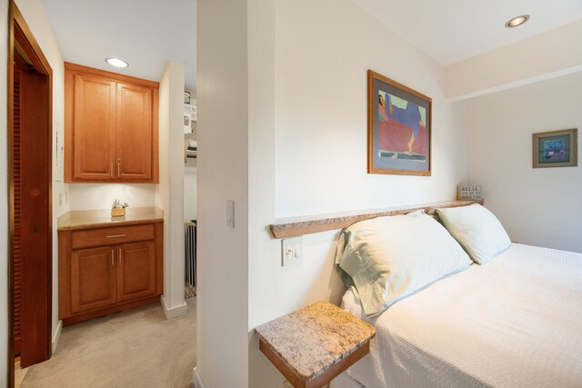 bedroom featuring light colored carpet and radiator