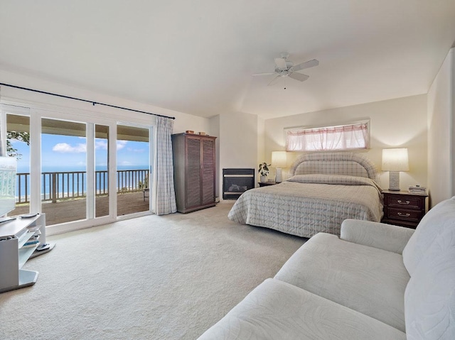 carpeted bedroom with access to outside, a water view, multiple windows, and ceiling fan