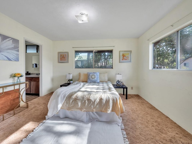 carpeted bedroom featuring ensuite bath