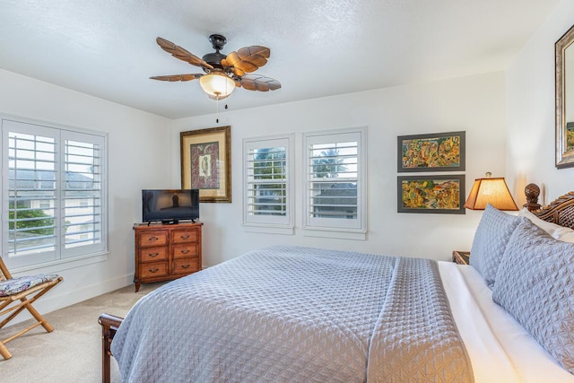 carpeted bedroom with ceiling fan and a textured ceiling