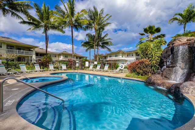 view of pool featuring pool water feature and a hot tub