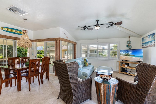 living room featuring light carpet, ceiling fan with notable chandelier, a wealth of natural light, and lofted ceiling