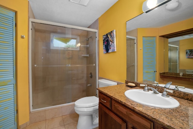 bathroom with tile patterned floors, a textured ceiling, toilet, vanity, and a shower with shower door