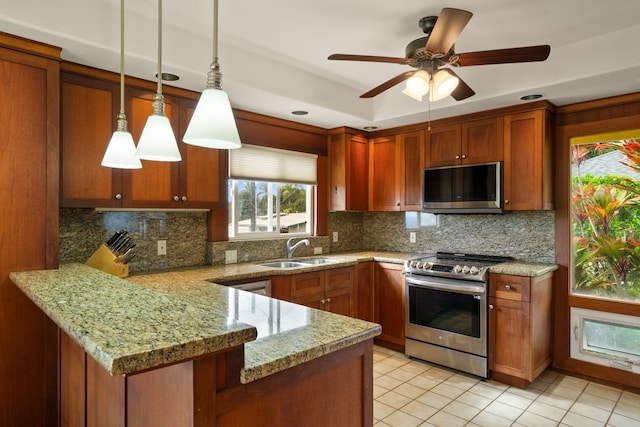 kitchen with sink, hanging light fixtures, backsplash, kitchen peninsula, and appliances with stainless steel finishes