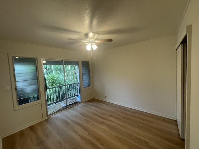 unfurnished bedroom featuring hardwood / wood-style floors, a textured ceiling, access to outside, and ceiling fan