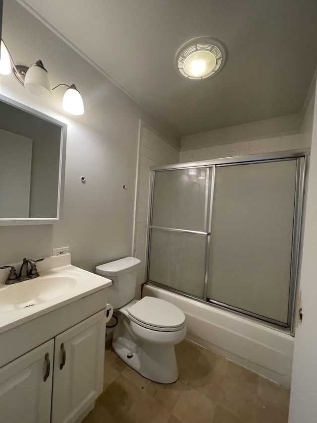 full bathroom featuring vanity, toilet, and shower / bath combination with glass door