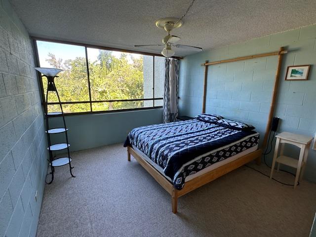 bedroom with a textured ceiling, ceiling fan, and light carpet