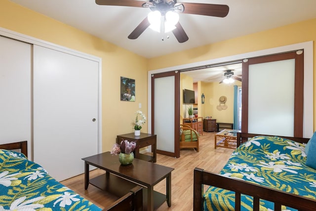 bedroom with ceiling fan, a closet, and light hardwood / wood-style floors