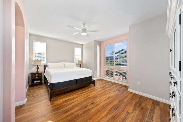 bedroom featuring multiple windows, hardwood / wood-style flooring, and ceiling fan