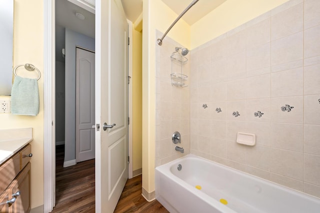 bathroom with vanity, wood-type flooring, and tiled shower / bath combo