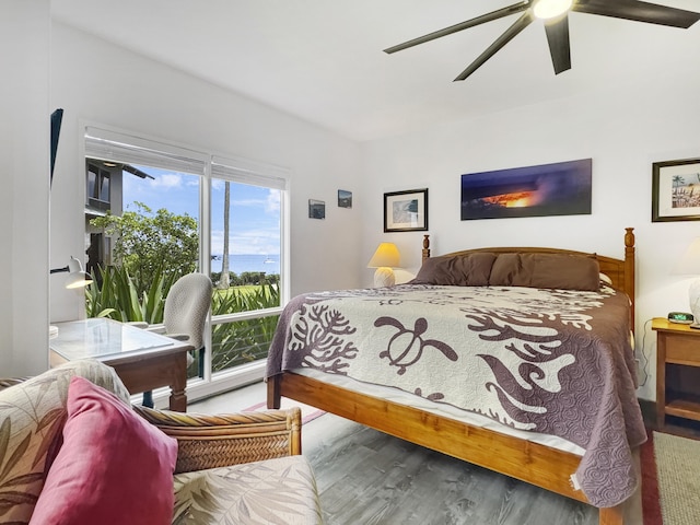 bedroom with access to exterior, wood-type flooring, and ceiling fan