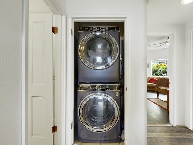 laundry area featuring stacked washer / dryer and dark hardwood / wood-style floors