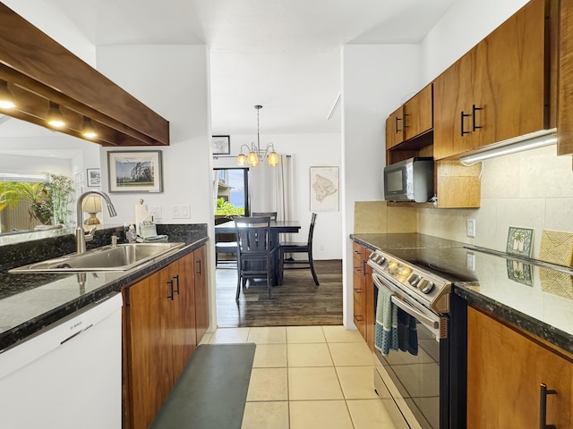 kitchen with light tile patterned flooring, sink, decorative light fixtures, dishwasher, and backsplash